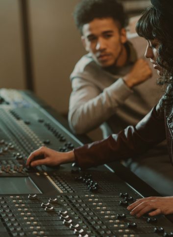 sound producers working with graphic equalizer at recording studio