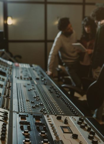 blurred group of musicians spending time at recording studio with graphic equalizer